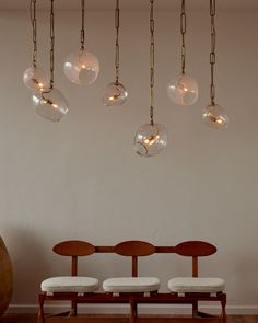 the lights are hanging from the ceiling above the chairs in the dining room, which is decorated with glass globes