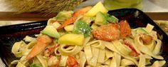 a plate of pasta with shrimp and vegetables