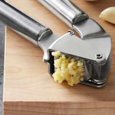 a knife with some food inside of it on a cutting board next to an apple peeler