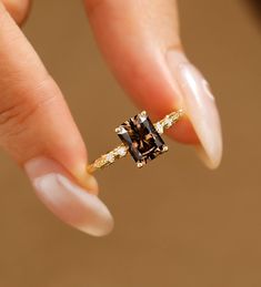 a woman's hand holding an engagement ring