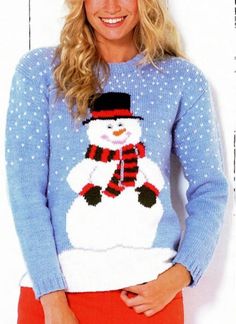 a woman is wearing a snowman sweater and red pants while posing in front of a white wall