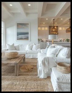 a living room filled with white furniture and lots of pillows on top of it's couches