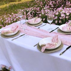 the table is set with pink napkins and place settings for two people to eat