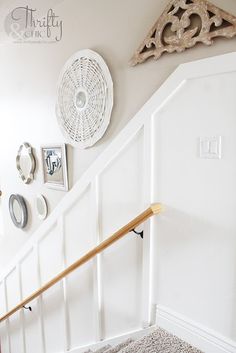 the stairs in this house are white and have wooden handrails on each side