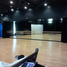 an empty dance studio with wooden floors and black curtains