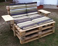 a couch made out of wooden pallets sitting in the grass