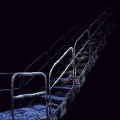 the stairs are covered in snow at night, with no people on them or one person walking up it