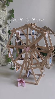 an origami ferris wheel with pictures attached to it and the words love is in the background