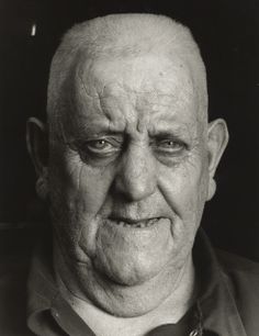 an old man is looking at the camera while wearing a collared shirt and tie