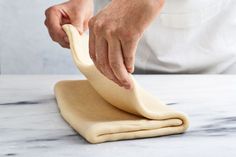 a person kneading dough on top of a table