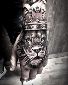 a hand with a lion wearing a crown on it