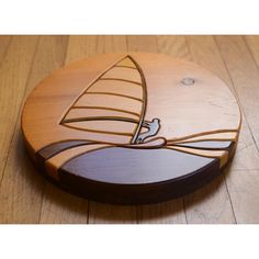 a wooden coaster with a sailboat on it