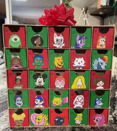 a wooden toy chest with cartoon characters painted on the front and sides, tied with a red bow