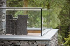 two chairs sitting on top of a stone wall next to a table and chair set