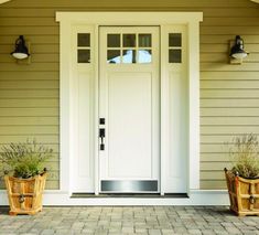 two wooden planters sitting on the side of a house next to a white door