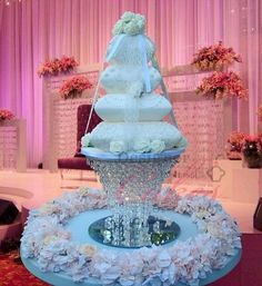 a wedding cake that is sitting on top of a table with flowers in the middle