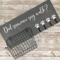 a sign that says, did someone say walk? with paw prints on it next to a basket