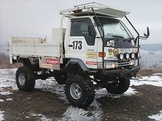 a white truck parked on top of a snow covered field