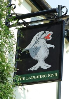 the laughing fish sign is hanging from the side of a building