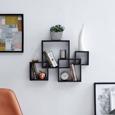 three black shelves with books and vases on them