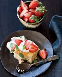 there is a piece of cake with strawberries on it and a bowl of strawberries in the background