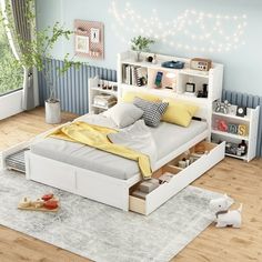 a white bed sitting on top of a wooden floor next to a book shelf filled with books