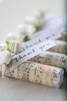 two rolled up sheet music notes with flowers on them and the words thank you written on them