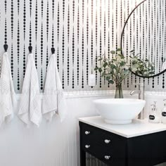 a white sink sitting under a mirror next to a black and white wall mounted faucet