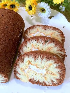 four pieces of cake on a white plate with yellow flowers in the backgroud