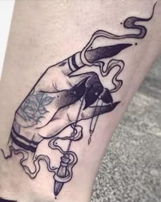 a tattoo on the leg of a person holding a knife