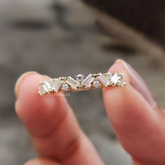 a person holding a diamond ring in their hand