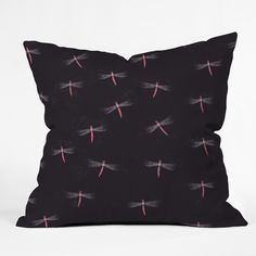 a black pillow with pink and white dragonflies printed on it's front side