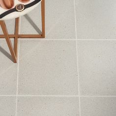 a woman's shoes are sitting on top of a stool in front of a tiled floor