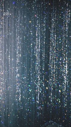 an abstract background with lots of small white and blue beads hanging from it's ceiling