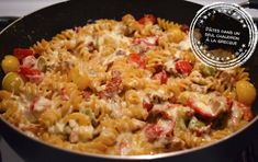 a skillet filled with pasta and vegetables on top of a stove next to an award seal