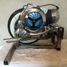 a clock made out of a motorcycle engine on a stand with wheels attached to it