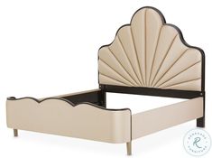 an upholstered bed with a shell shaped headboard and foot board on it