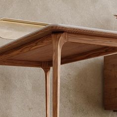 a bird sitting on top of a wooden table next to a wall mounted light fixture