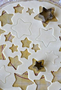 cookies are arranged in the shape of stars and maple leaves on top of a cookie sheet