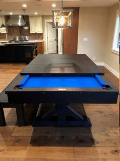 a pool table in the middle of a kitchen with blue lights on it's sides