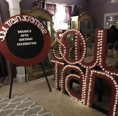 two large lighted letters that are sitting on the floor in front of a table and mirror