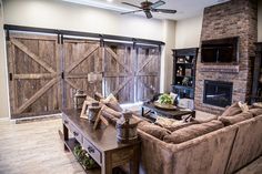 a living room filled with furniture and a flat screen tv mounted to a wall next to a fire place