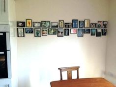 a dining room table and chairs with pictures on the wall