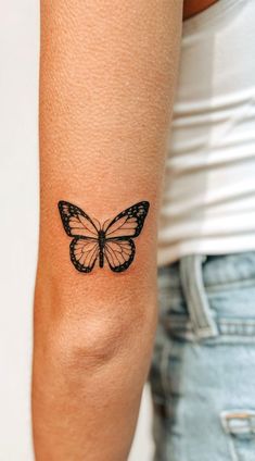 a woman's arm with a tattoo of a butterfly on the back of her arm