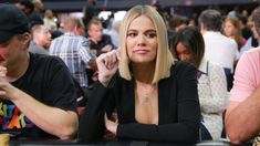 a woman sitting at a table in front of other people with poker chips around her