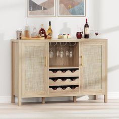 a wooden cabinet with wine glasses and bottles on the top, next to two framed pictures