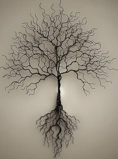 a metal tree with roots hanging from it's sides