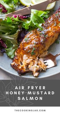 a plate with salmon, lettuce and lemon wedges on it that says air fryer honey mustard salmon