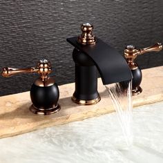 two faucets with black and gold fixtures