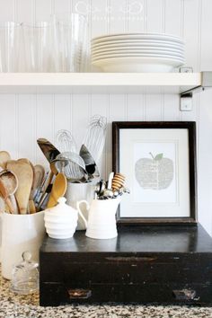 kitchen utensils are sitting on top of an old dresser in front of the shelves